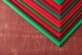 Stack of red and green fabrics on brown background, space for text Royalty Free Stock Photo