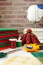 Stack of red and green fabrics, sewing and quilting accessories and sewing machine on brick wall background Royalty Free Stock Photo