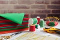 Stack of red and green fabrics surrounded by sewing and quilting accessories on brick wall background Royalty Free Stock Photo