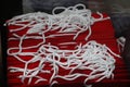 A stack of red paper bags with white rope handles.