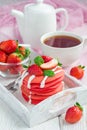 Stack of red velvet pancakes with yogurt and strawberry on on a wooden tray, vertical