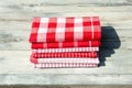 Stack of red white checkered and striped tableclothes on rustic Royalty Free Stock Photo