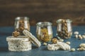 American puffed rice cakes. Healthy snacks with almonds, raisins, peanuts, pistachios in glass jars on classic blue concrete Royalty Free Stock Photo