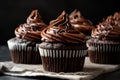 stack of rich chocolate cupcakes, with swirls of creamy frosting