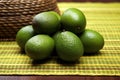 a stack of ripe avocados on a woven mat