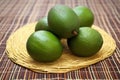 a stack of ripe avocados on a woven mat