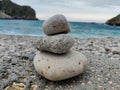 Stack of rocks on stony beach in Taormina. View with sea Water and sky.
