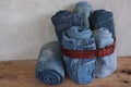 Stack roll blue denim jeans and Leather Belt on wood