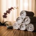 Stack of Rolled White Spa Towels with Smooth Stone and Orchid in Soft Focus Background wellness Royalty Free Stock Photo