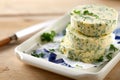 Stack of round butter pats flavored with parsley