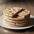 A stack of round, flatbreads sits on a white plate, each showing a Royalty Free Stock Photo