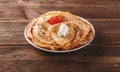Stack of russian pancakes blini with red caviar, fresh sour cream