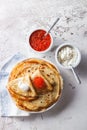 Stack of russian pancakes blini with red caviar, fresh sour cream