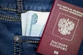 A stack of Russian thousand-ruble bills in a pocket of blue jeans and a Russian international passport. Money in your pocket, cash Royalty Free Stock Photo