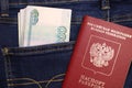 A stack of Russian thousand-ruble bills in a pocket of blue jeans and a Russian international passport. Money in your pocket  cash Royalty Free Stock Photo