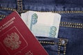 A stack of Russian thousand-ruble bills in a pocket of blue jeans and a Russian international passport. Money in your pocket  cash Royalty Free Stock Photo