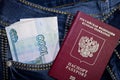 A stack of Russian thousand-ruble bills in a pocket of blue jeans and a Russian international passport. Money in your pocket, cash Royalty Free Stock Photo