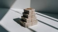 A stack of rustic gift boxes tied with twine on a white surface. The minimalist scene is lit by bright sunlight, creating dramatic Royalty Free Stock Photo