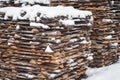 Stack of sawn planks covered with snow. Sawmill background.A large pile of boards on the street is covered with snow. Stop boards