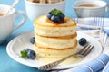 A stack of scotch pancakes with with honey and blueberries on a breakfast table Royalty Free Stock Photo