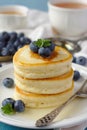 A stack of scotch pancakes with with honey and blueberries on a breakfast table Royalty Free Stock Photo