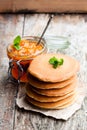 Stack of scotch pancakes with orange jam on wooden table