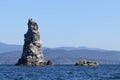 Stack in the sea on mountains background in sunny day. Deep blue water and clear sky with no clouds. Background, wallpaper or temp Royalty Free Stock Photo