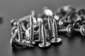 Stack of self-tapping screws, grey background