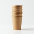 Stack of seven brown, disposable paper cups placed vertically on a white surface. Royalty Free Stock Photo