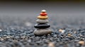 A stack of seven stones in black, gold, red, and white sits on a pebble beach. Royalty Free Stock Photo