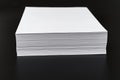 a stack of sheets of white paper on a black background. Royalty Free Stock Photo