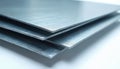 Stack of shiny metal sheets with brushed texture in clean workshop. Gray material closeup shows smooth metallic surface, Royalty Free Stock Photo