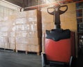 Stack of shipment boxes and electric forklift pallet jack at the warehouse. Cargo export & shipping warehousing, Logistics and tra