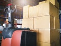 Stack of shipment cardboard boxes with electric forklift pallet jack at manufacturing warehouse storage. Cargo export Royalty Free Stock Photo