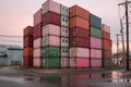 stack of shipping containers near a warehouse building