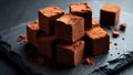 Stack of Dark Milk Chocolate Cubes with Cocoa Powder and Hazelnut Pieces on Parchment Paper Royalty Free Stock Photo