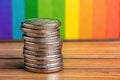 Silver Coins Stacked on Wooden Surface Against Rainbow Background Royalty Free Stock Photo