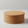 A stack of six cork coasters is neatly arranged on a smooth, white surface. The Royalty Free Stock Photo