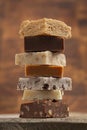 Stack of Six Different Types of Fudge with a Wooden Background