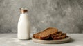 a stack of sliced brown bread on a plate alongside a milk bottle, set against a grey background for a sleek and simple Royalty Free Stock Photo