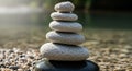 A stack of smooth, rounded stones balanced on one another, located near a body of water. The stones Royalty Free Stock Photo