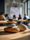 Stack of smooth stones on a wooden table in a modern classroom setting Royalty Free Stock Photo