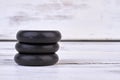 Stack of spa hot stones on white wooden background. Royalty Free Stock Photo