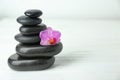 Stack of spa stones and beautiful flower on white table Royalty Free Stock Photo