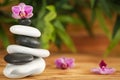 Stack of spa stones with beautiful orchid flower on blurred background Royalty Free Stock Photo