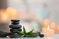 Stack of spa stones and burning candles on blurred background Royalty Free Stock Photo