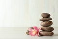 Stack of spa stones and flower on table against white background Royalty Free Stock Photo