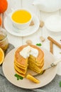 Stack of spicy pumpkin pancakes on a plate with honey and whipped cream on a white wooden background. Royalty Free Stock Photo