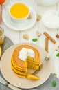 Stack of spicy pumpkin pancakes on a plate with honey and whipped cream on a white wooden background. Royalty Free Stock Photo