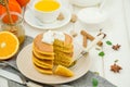 Stack of spicy pumpkin pancakes on a plate with honey and whipped cream on a white wooden background. Royalty Free Stock Photo